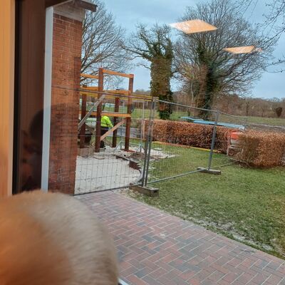Das Bild zeigt ein Kind, das neugierig aus dem Fenster auf die Baustelle schaut