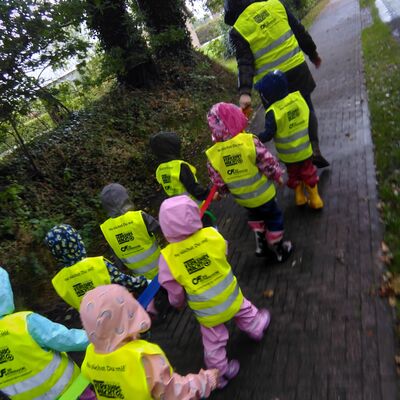 Das Bild zeigt eine Kindergartengruppe beim Spaziergang. Alle Kinder tragen Wahrnwesten.