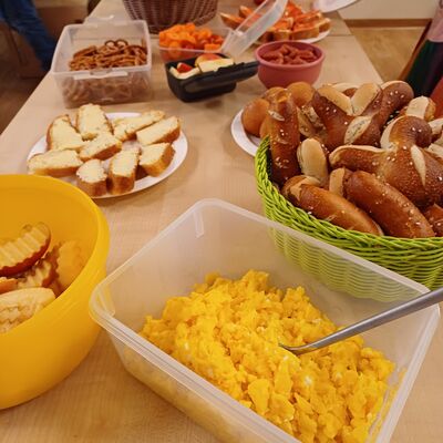 Das Bild zeigt einen gedeckten Tisch mit vielen Snacks als Buffet