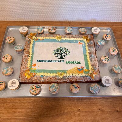 Das Bild zeigt einen Kuchen mit dem Logo der Kita-Jübberde.