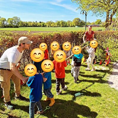 Das Bild zeigt, wie die Kita-Kinder den Maibaum zum Erdloch tragen.