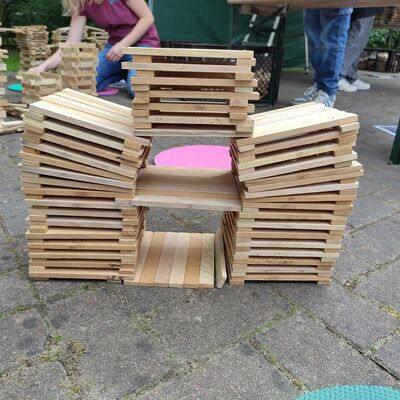 Bild vergr&ouml;&szlig;ern: Das Bild zeigt ein komplexes Bauwerk aus Holzstäben mit angewinkelten Dächern.