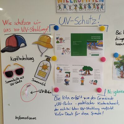 Das Bild bildet die Pinnwand der Kita ab, auf der Elterninfos zum Thema "UV-Schutz" präsentiert werden.