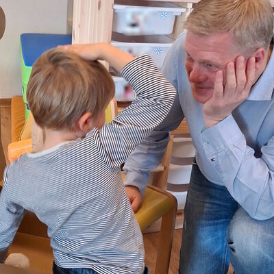 Auf diesem Foto hört Ulf Thiele (CDU) einem Kind aufmerksam zu.