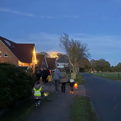 Das Foto zeigt den Laternenumzug im Dämmerlicht.