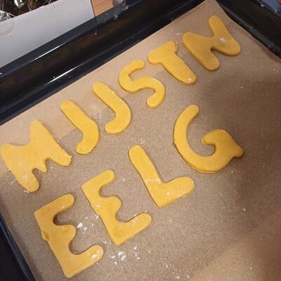 Bild vergr&ouml;&szlig;ern: Das Bild zeigt ein paar ungebackene Buchstabenkekse auf einem Backblech.