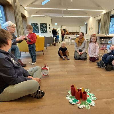 Das Foto zeigt einen Sitzkreis in den Räumen der Upkamer in Remels mit Kindern der Ahorngruppe und Vertreterinnen des Seniorenbeirats.