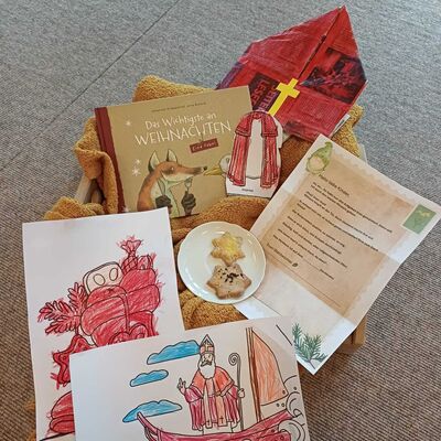 Das Foto zeigt ein Tablett gefüllt mit den Dingen, die der Wichtel in seinem Brief fordert. Darunter eine gebastelte Mitra, eine Weihnachtsgeschichte, ein Schälchen mit Plätzchen und gemalte Bilder.